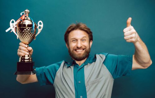 benefits of design awards banner featuring man holding trophy